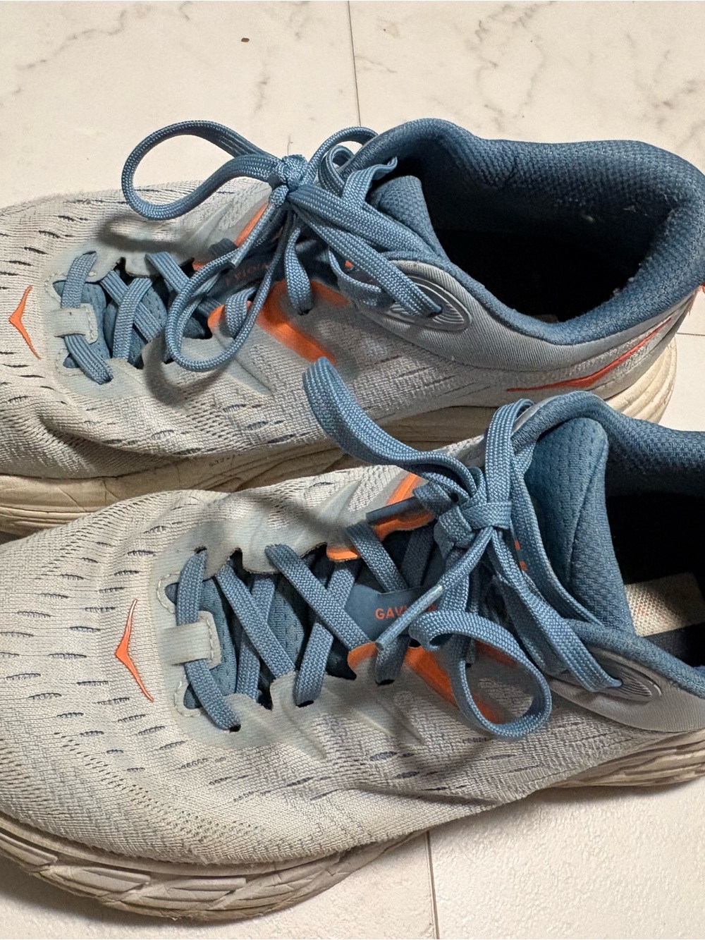 Hoka light blue sneakers with orange logo